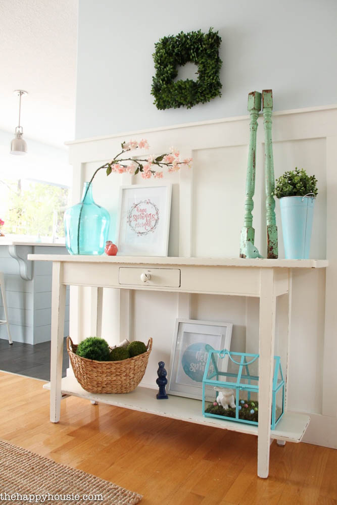 A small console table in the dining room is filled with spring items.