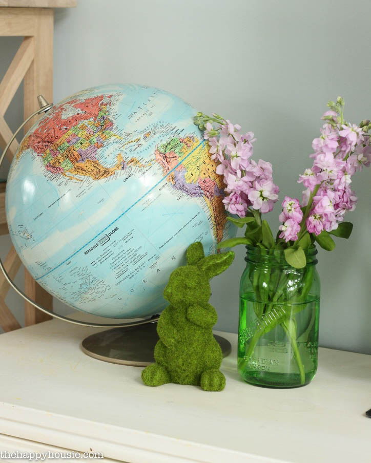 There is a wold map globe on the console table.