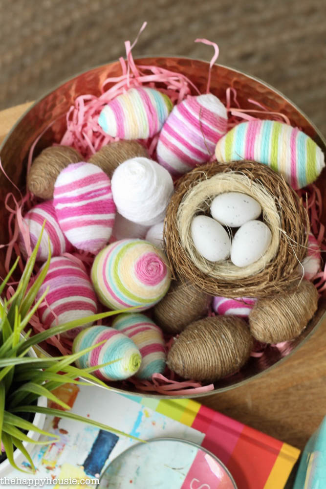 Decorated Easter eggs are in a basket on the table.