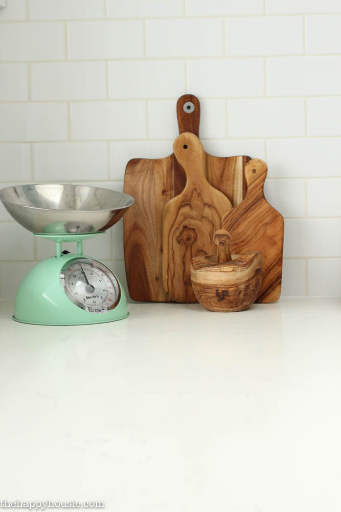 There is a small scale and wooden cutting boards in the kitchen.