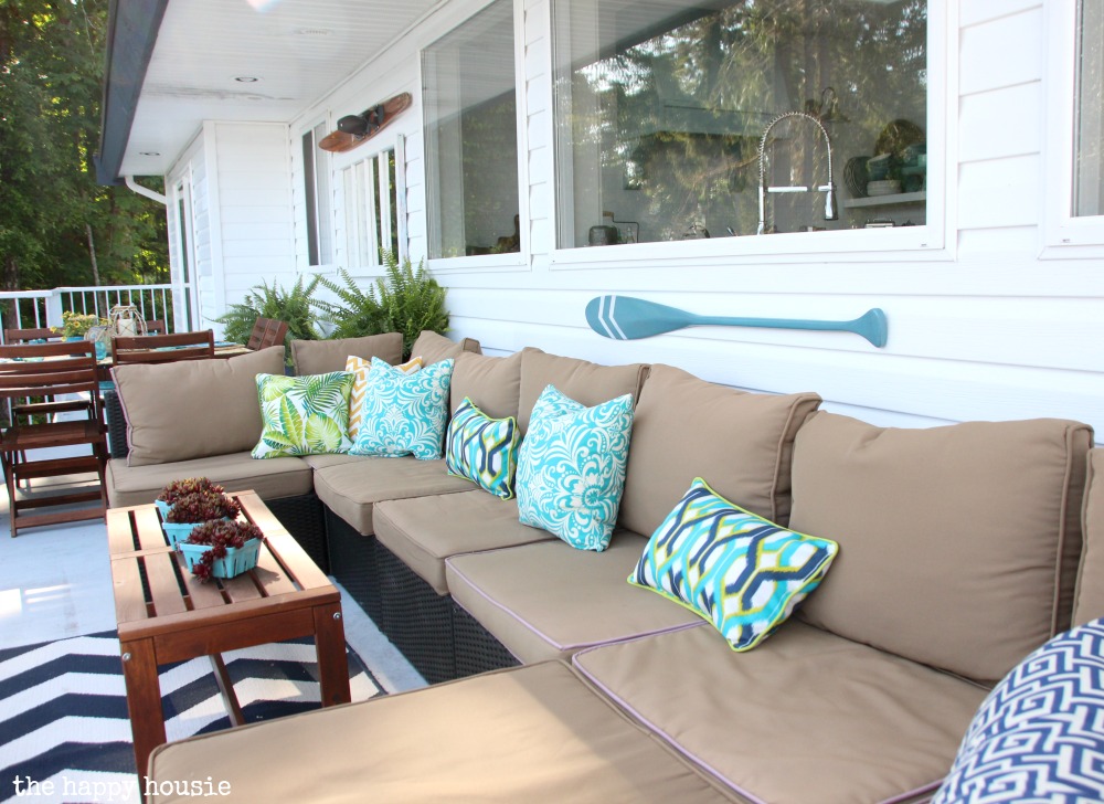 A sectional outdoor couch with bright blue pillows.