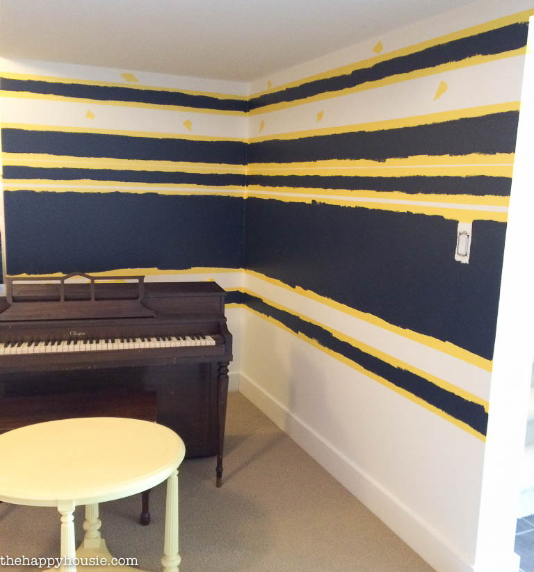 The corner of the room with a piano in the corner of the room.