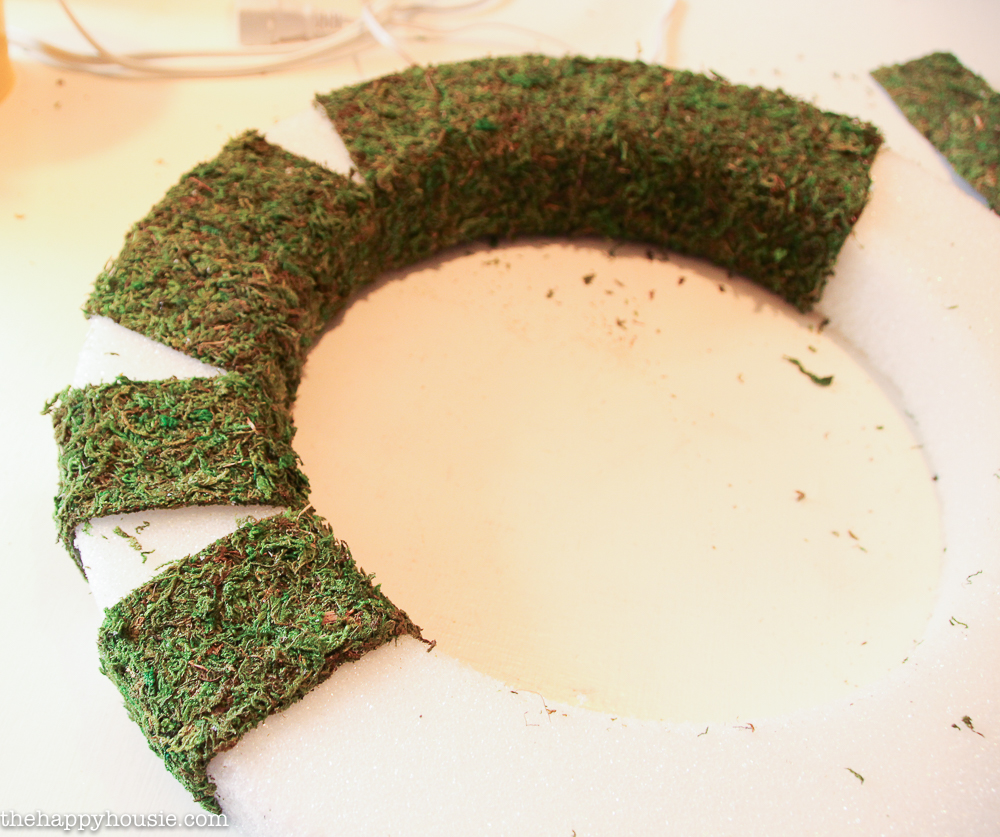 Forming the strips of moss around the wreath form.