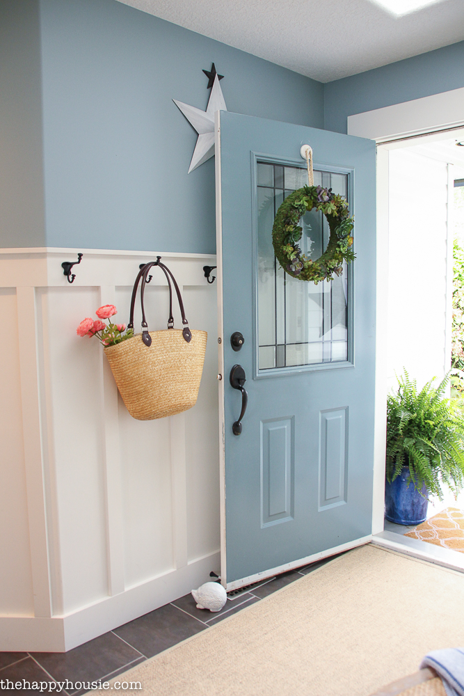 The door is opened with a small bag filled with flowers on a coat hook.