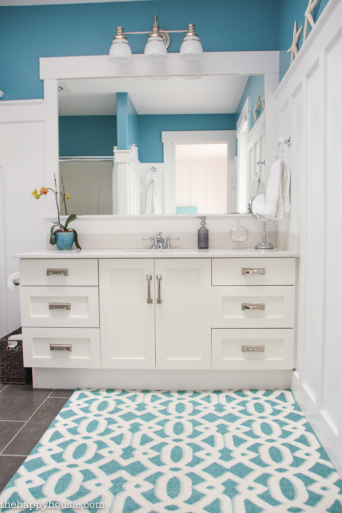 A blue and white wall and rug in the bathroom.