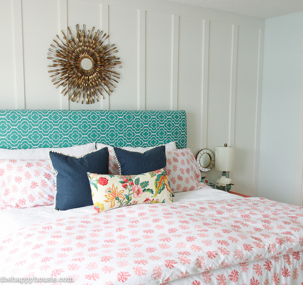 A turquoise and white headboard is on the bed.