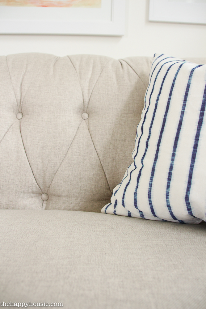A striped blue and white pillow is on the couch.