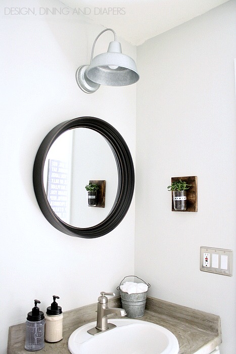 A black round mirror in a small bathroom.