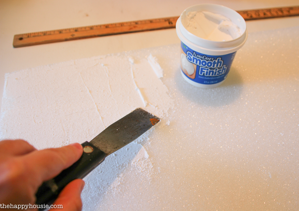 Applying the smooth finish with the putty knife.