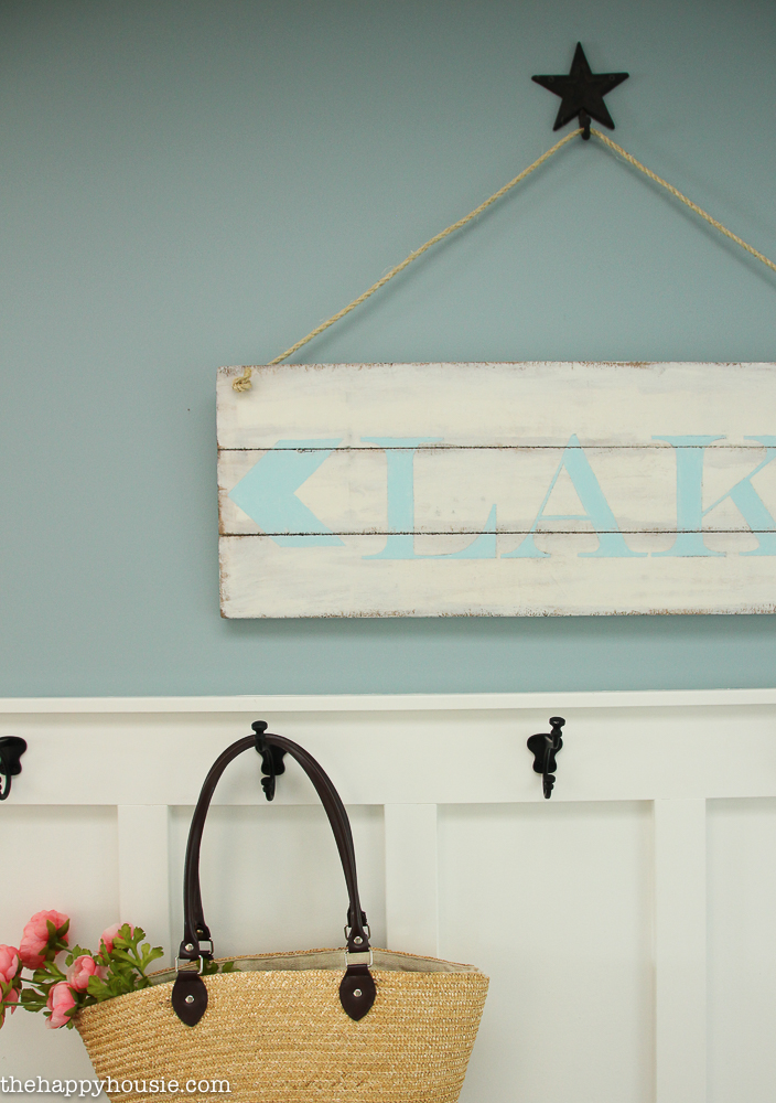 The lake sign hanging on the wall with a star hook.