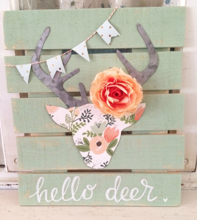 A floral deer head with antlers and a rose.