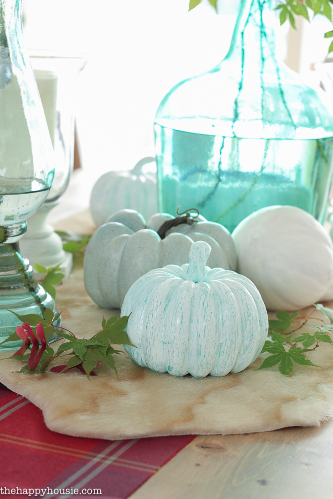 A light blue crackle pumpkin on a display in the middle of the table.