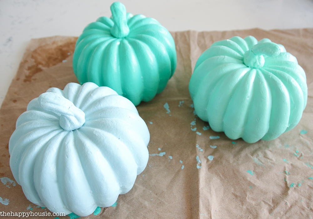 Painting the pumpkins a variety of shades of green and blue.