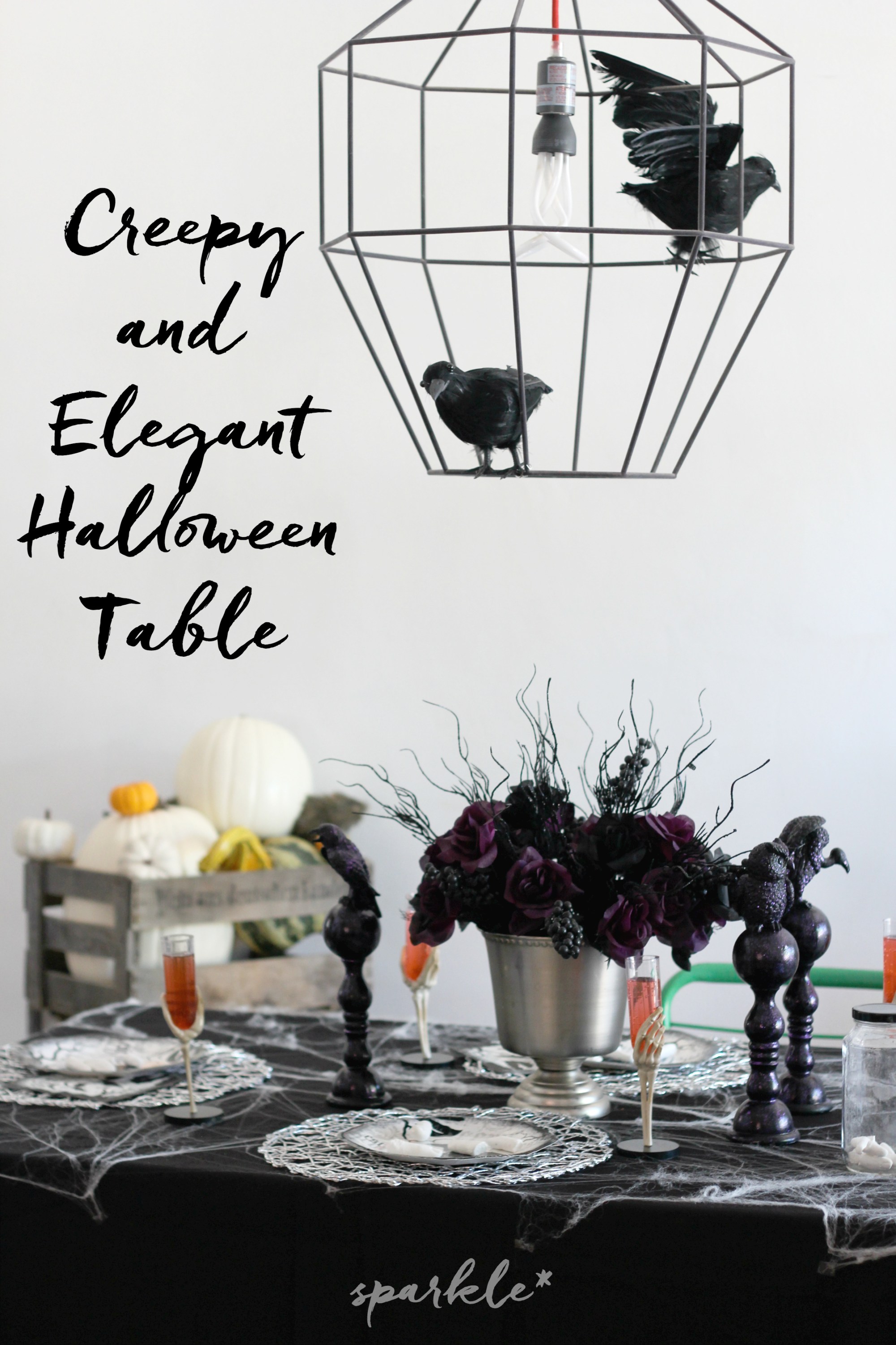 Creepy and elegant Halloween table that is in black with spider webs and dark flowers.