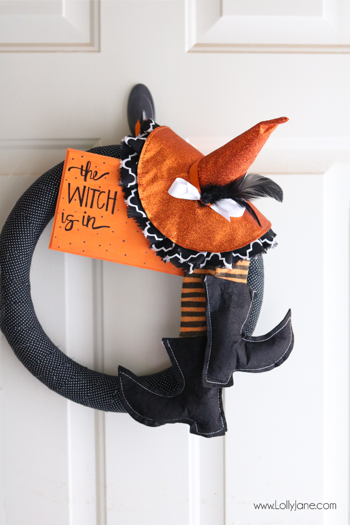 A Halloween wreath with black and orange boots and hat.