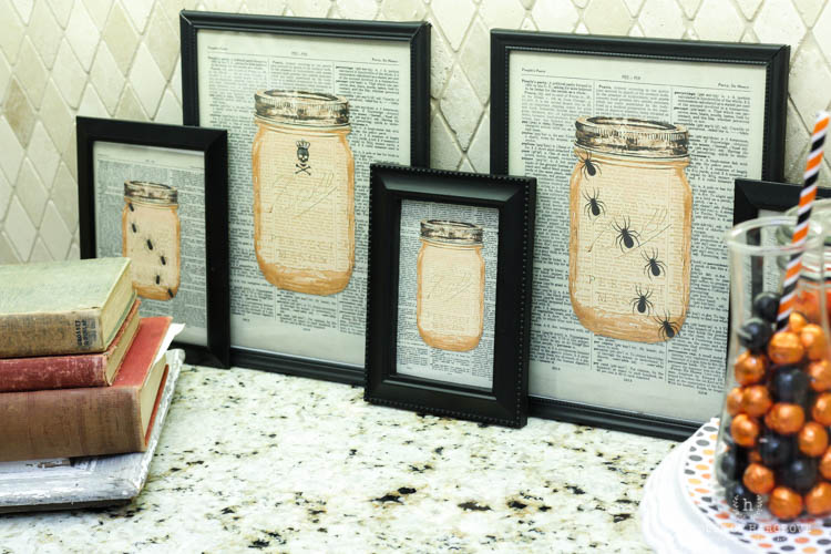 Halloween printables that are in a black frame on the table.