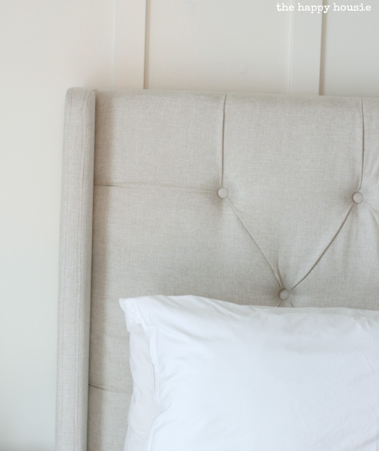 Up close look at the tufted white headboard.