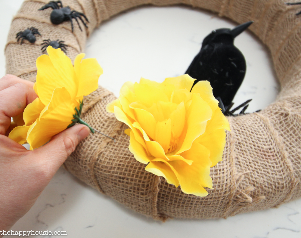 Attaching yellow flowers to the wreath.