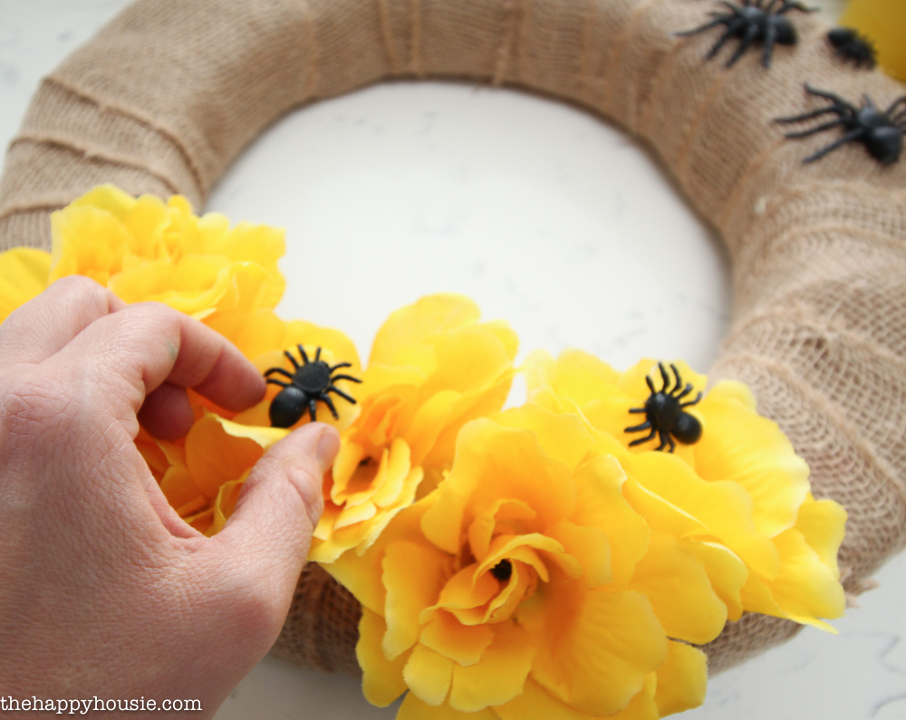 Putting the black spiders onto the yellow flowers on the wreath.
