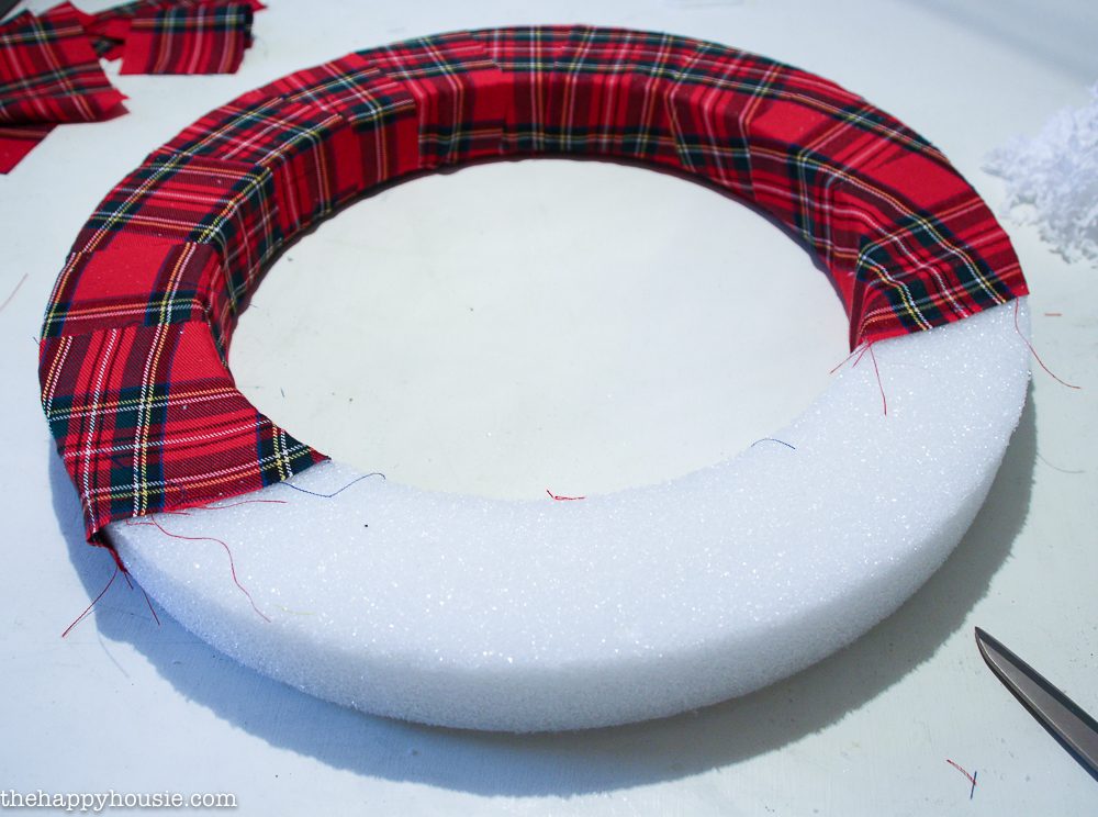 Putting the red plaid fabric onto the foam circle.