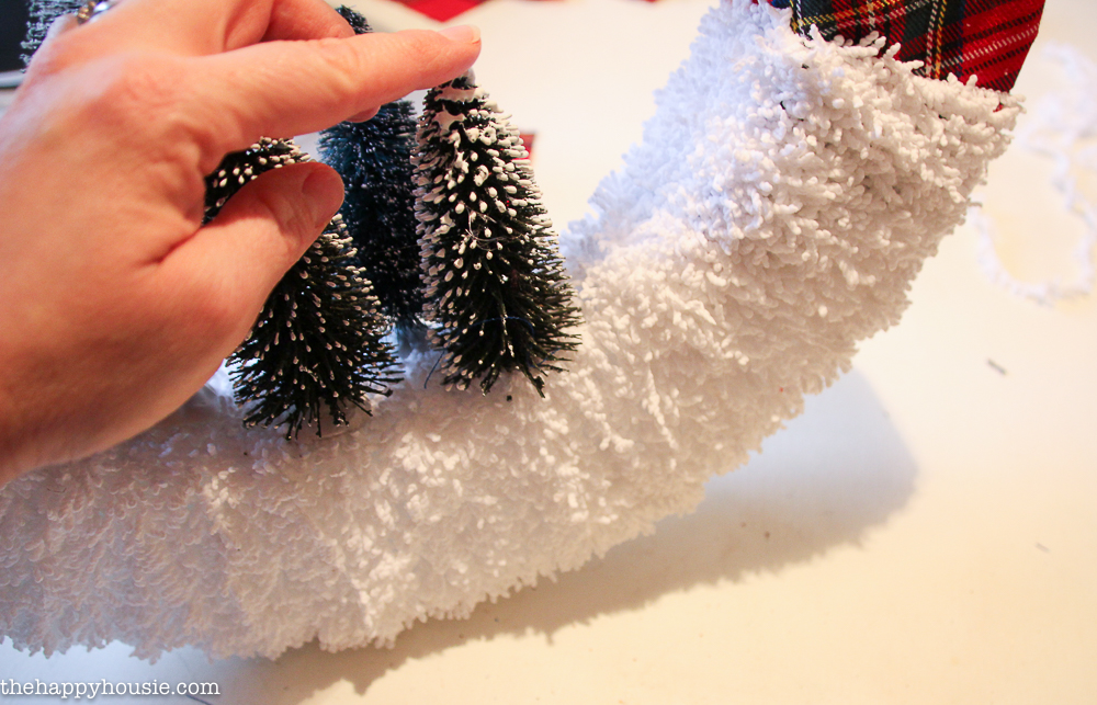 Attaching the bottle brush trees to the wreath.