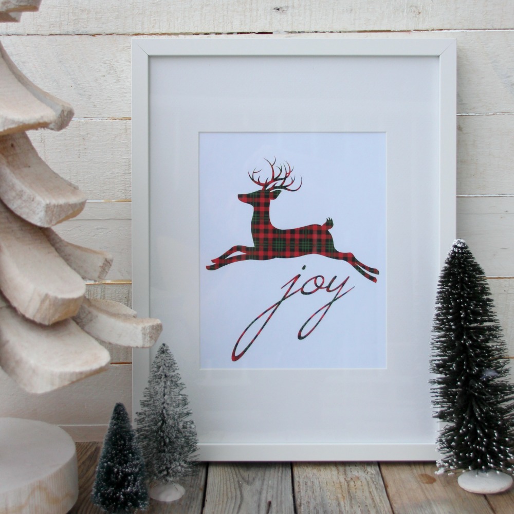 A plaid reindeer and the word Joy framed.