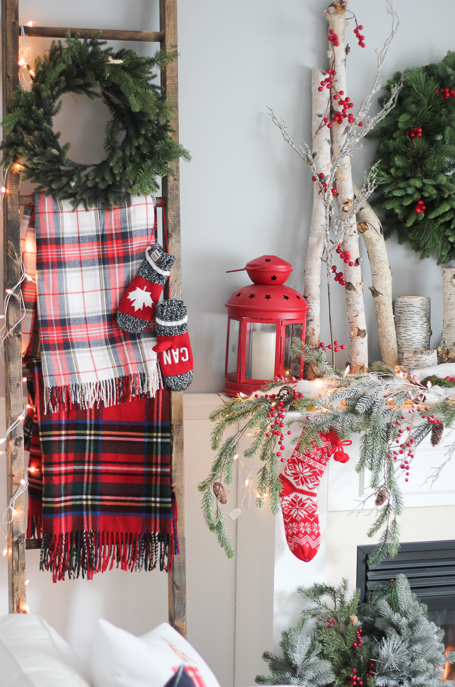 A wooden blanket ladder with plaid blankets and a wreath on it.