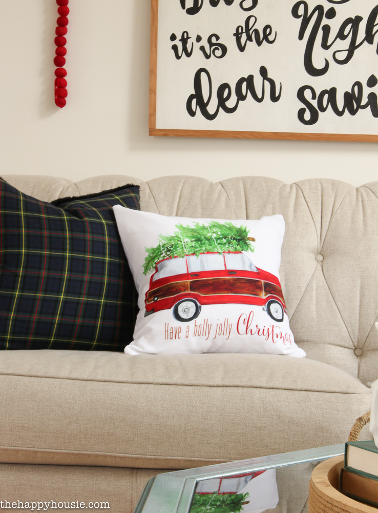 A classic red truck carrying a Christmas tree on the roof pillow.