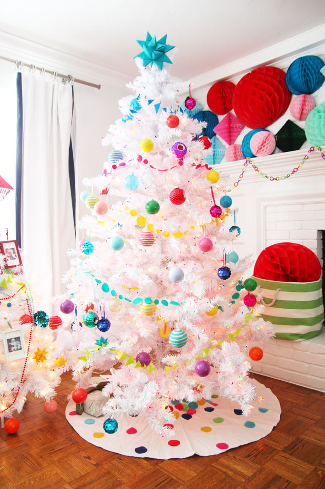A white Christmas tree with multi coloured decorations on it.