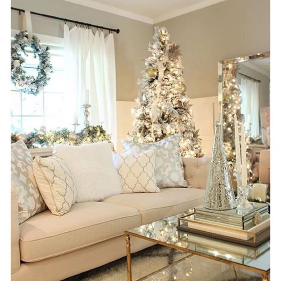 There is a large neutral couch with neutral pillows and a Christmas tree beside it.