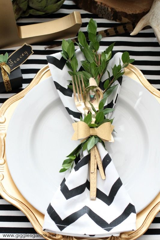 A place setting in gold with a black and white napkin.