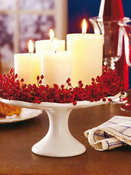 A cake stand with red berries and candles.