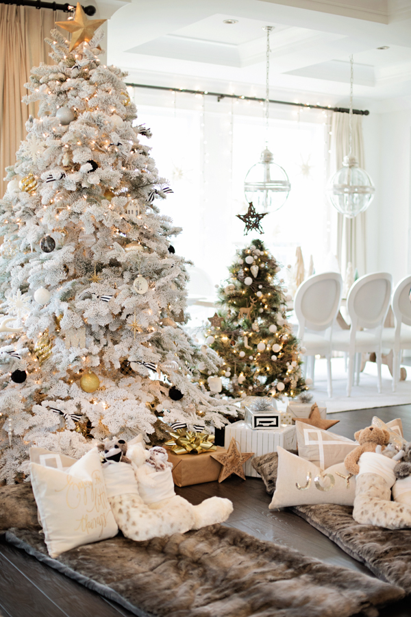 A white tree with faux fur and presents under it.