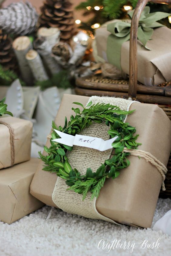 Neutral wrapping paper with a small green wreath on it and burlap ribbon.