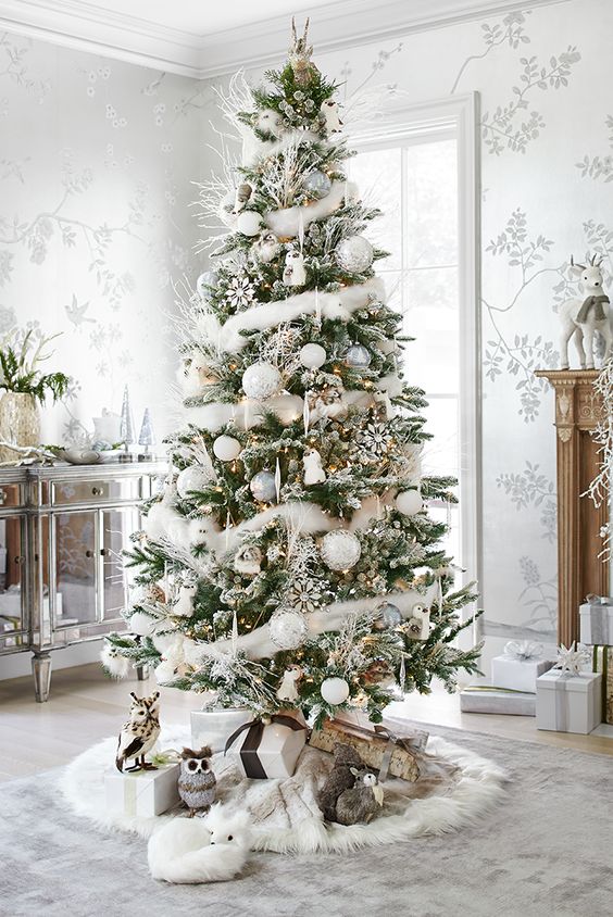 A glamorous large Christmas tree in the middle of a room.