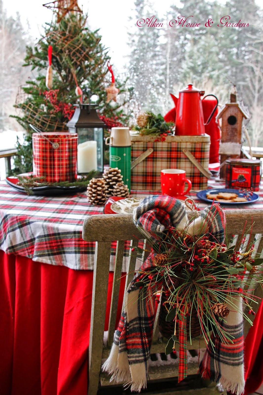 A table outside decorated in plaid and sprigs of evergreen.