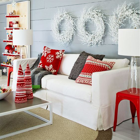 White couch with red Christmas pillows.