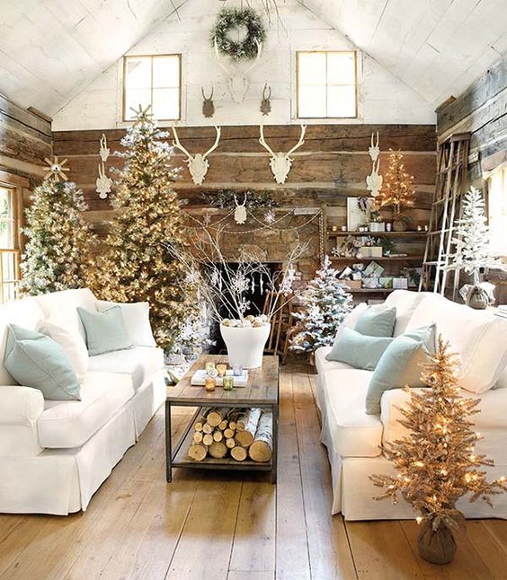 A rustic cabin feeling living room with white couches and antlers.