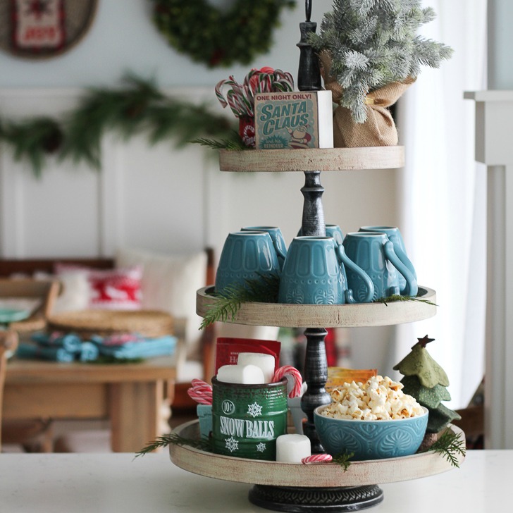 A tiered tray with a hot chocolate holiday stuff on it.