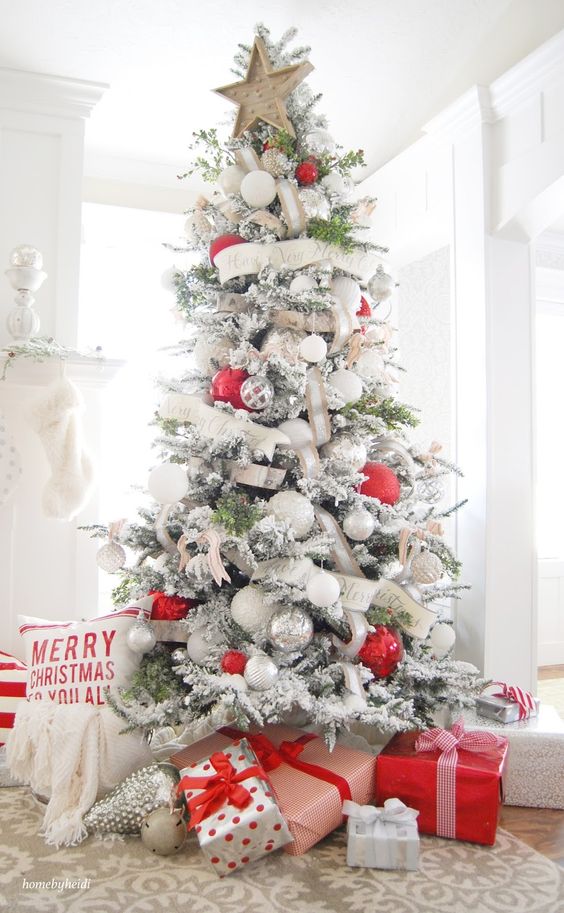 A white flocked tree with red and white presents underneath.
