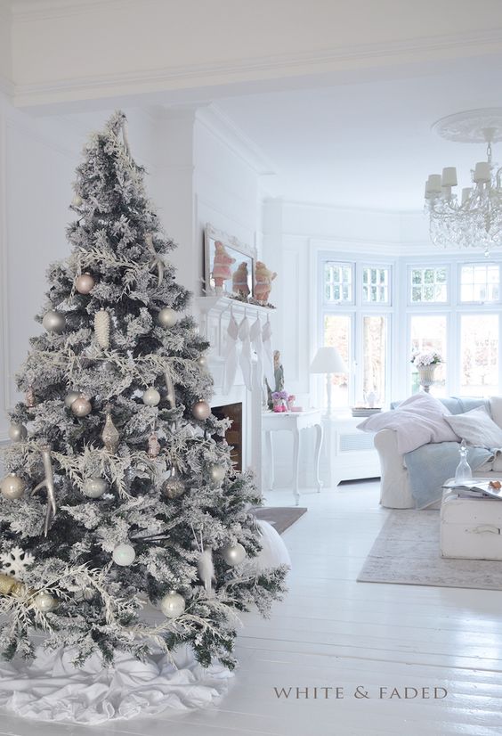 White and wood floors, white chairs and couches and a white tree.