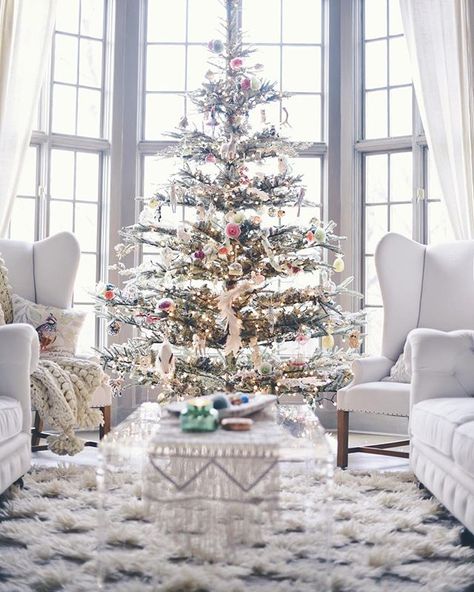 A bay window with a large Christmas tree.