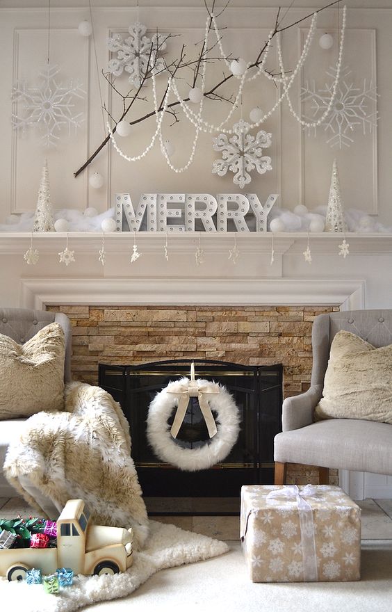 Two neutral chairs that flank a white fireplace mantel.