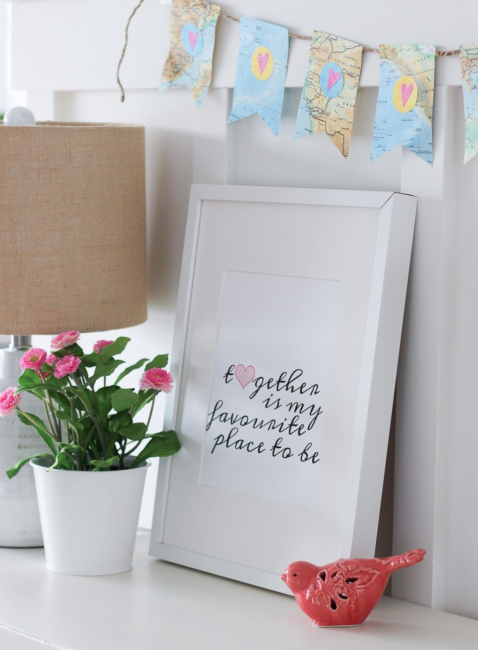 There is a pot of flowers and a little pink bird beside the printable.