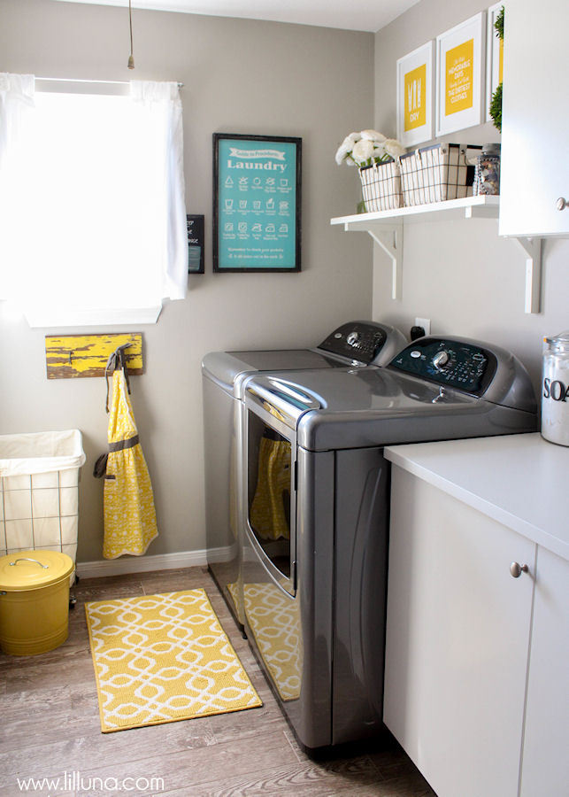 There is a yellow and white patterned rug in front of the washing machine.