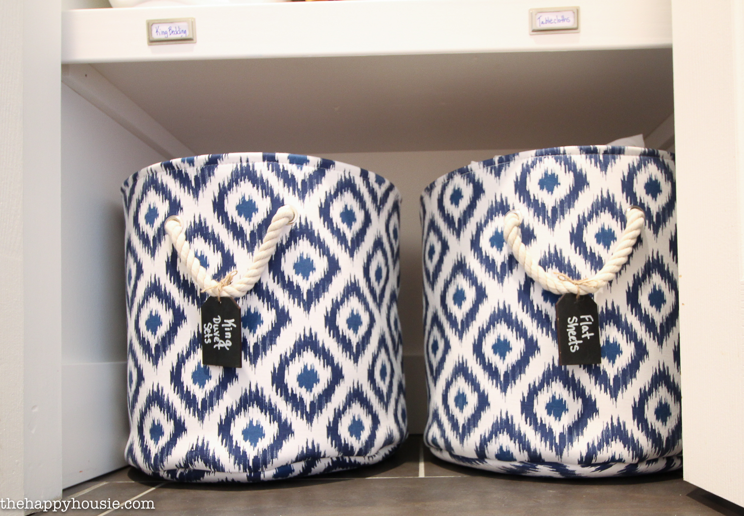 Blue and white baskets that are labeled for the linen.