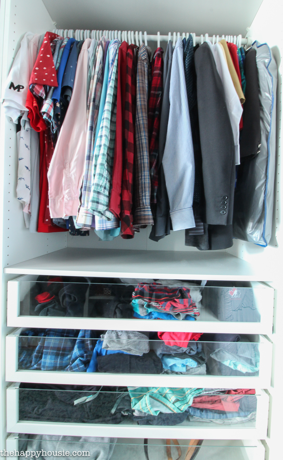 Button down shirts hang in the closet.