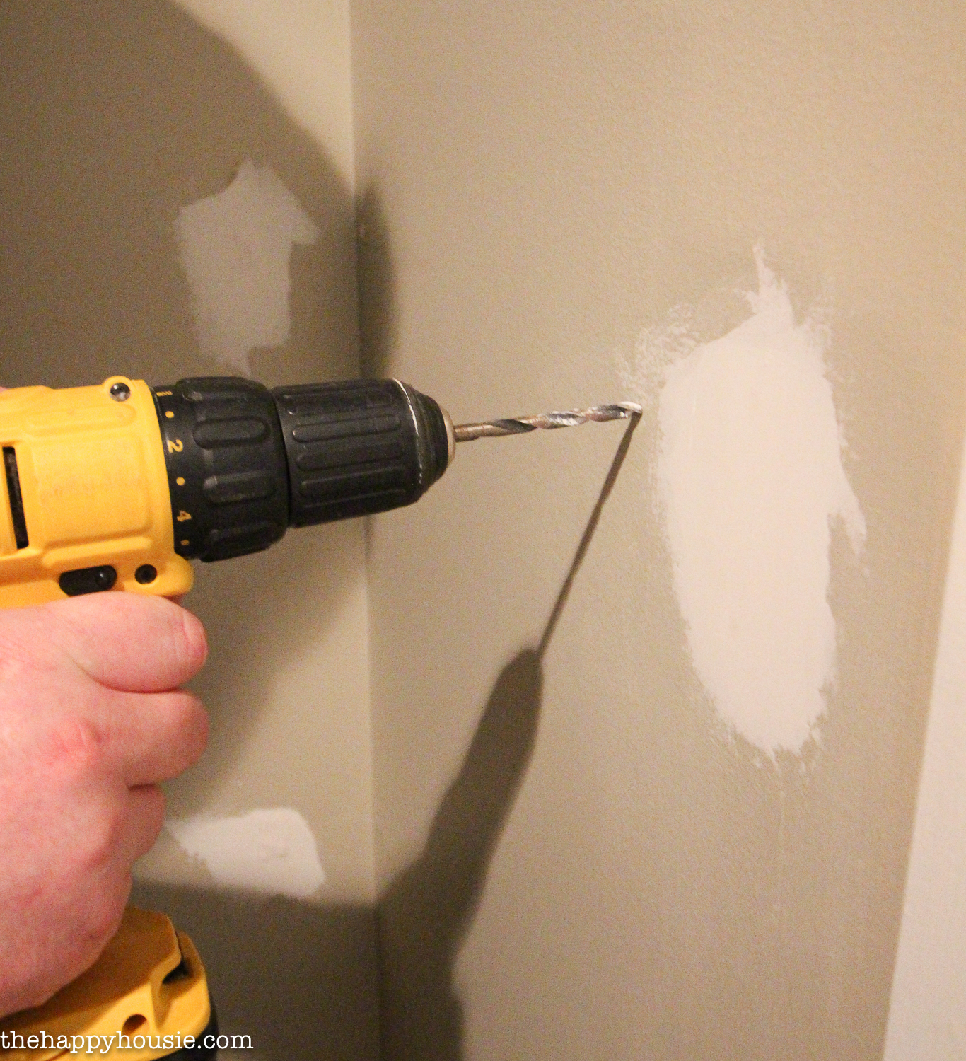 Drilling into the wall.