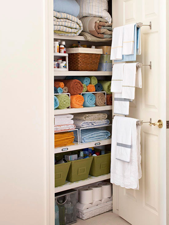 Colourful rolled up towels are in this linen closet.