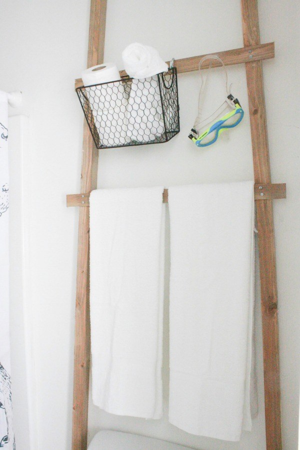 A faux bathroom ladder with towels on it drying.